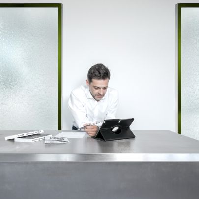 Mann arbeitet an Laptop, dahinter Wasserfall-Kühlung