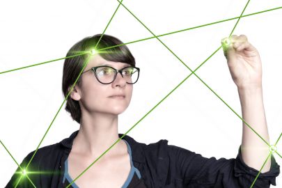 Eine junge Frau malt mit einem Stift Lichtpunkte in ein virtuelles Netz aus grünen Linien.