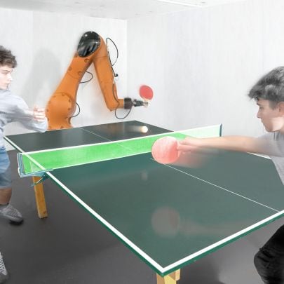 Zwei Jungen spielen einen Tischtennis-Rundgang mit einem Industrieroboter.7