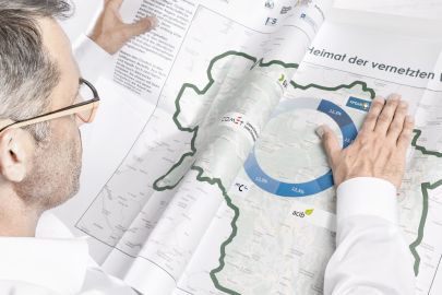 Mann streicht Zeitung mit Steiermark-Landkarte glatt