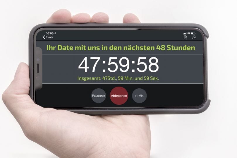 Hand mit Handy. Auf dem Display steht: "Ihr Date mit uns in den nächsten 48 Stunden. 47:59:58