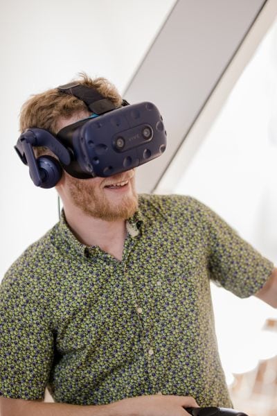 Mann mit Virtual-Reality-Brille und Joysticks in den Händen.