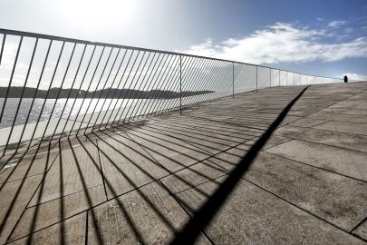 Brücke mit Geländer, See und Himmel