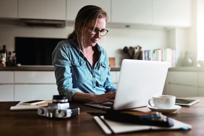 Frau arbeitet in Küche am Laptop