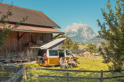 Campingbus vor Hütte und Berg