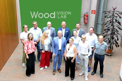 Menschengruppe vor grüner Tafel "Wood Vision Lab"